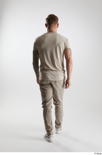 Gilbert 1 back view dressed grey t-shirt grey trousers walking…